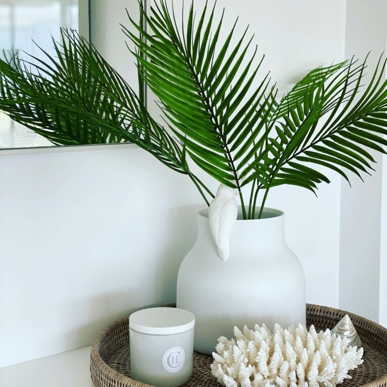 Stylish affordable home decor finds arranged on a shelf with candles, vases, and a plant