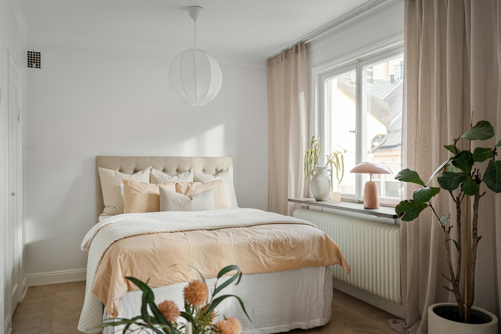 Small bedroom decorated on a budget with cozy neutral bedding and warm lighting